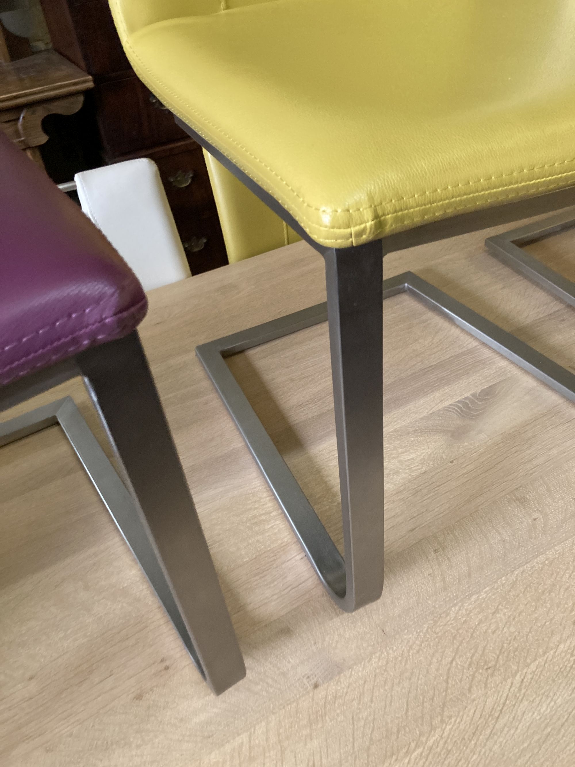 A set of eight contemporary stainless steel and leather-covered dining chairs